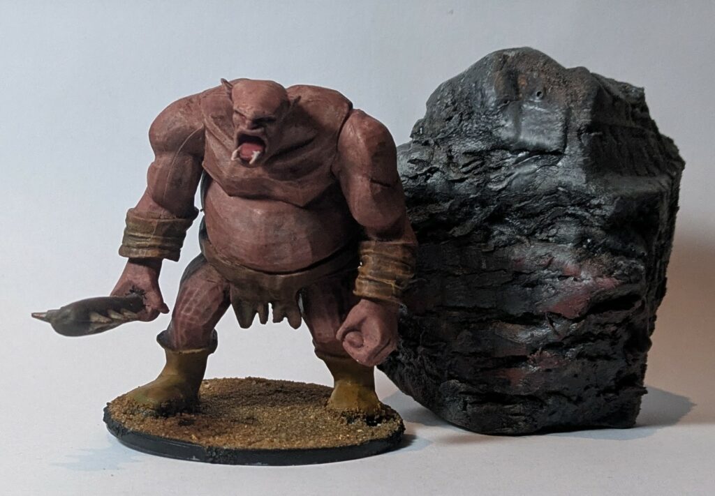 A pink / red troll near a stone covered in blood.