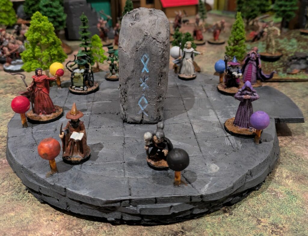 Eight mages, wizards, sorcerers and necromancer, in a miniature mage tower rooftop, with a magical stone in the center and an illithid climbing stairs