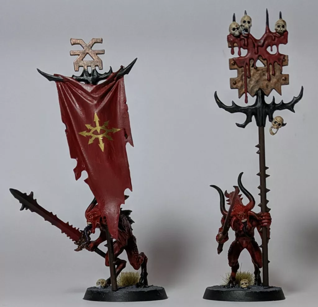 Two Warhammer 40K Khorne Chaos Daemons Bloodletters, they are wielding Khorne banners.