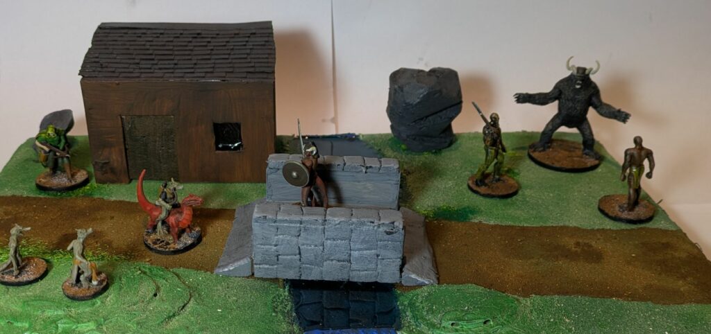 A terrain with grass on the ground, two small hills, a stone bridge and a hunting lodge.